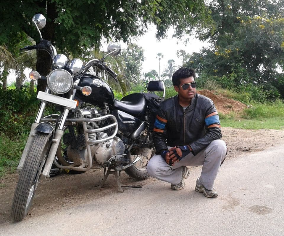 Jayanth sitting beside his motorcycle